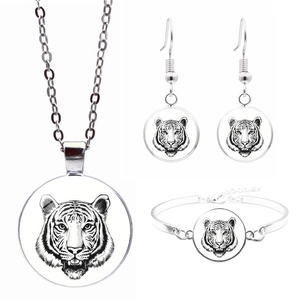 Détail de la parure de bijoux tête de tigre argentée avec collier, boucles et bracelet