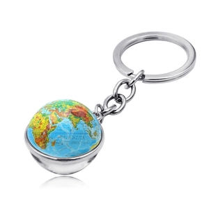 Vue macro d'un porte-clés globe terrestre en métal argenté avec carte du monde colorée