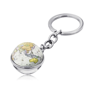 Gros plan du porte-clés globe terrestre en verre argenté avec reflet sur fond blanc