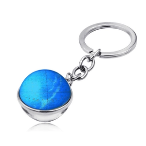 Gros plan détaillé d'un porte-clés argenté avec un pendentif globe céleste bleu