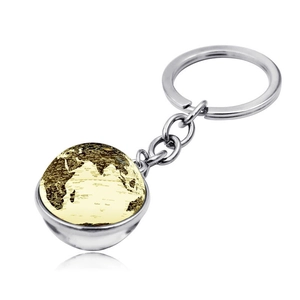 Gros plan d'un porte-clés globe avec carte du monde rétro sous verre et chaîne en métal