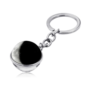 Detailed view of crescent moon phase double-sided glass ball keychain with silver metal ring