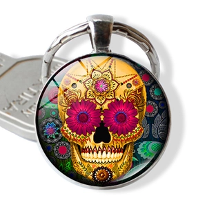 Nahaufnahme eines mexikanischen Sugar-Skull-Anhängers aus Glas mit silbernem Schlüsselring