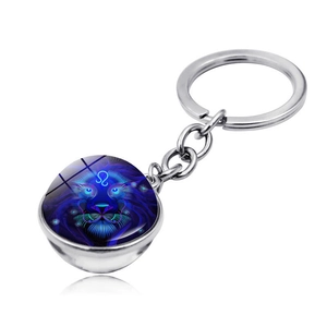 Detailed macro shot of Leo zodiac keychain with double-sided glowing glass ball and silver chain