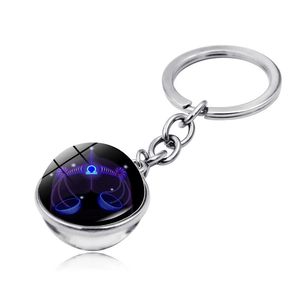 Detail of Libra zodiac keychain featuring a glowing double-sided glass ball on silver metal