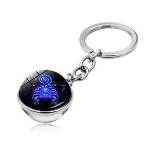 Detail of Scorpio zodiac keychain featuring a glowing double-sided blue glass ball pendant