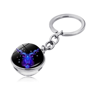 Detail of Capricorn glass orb keychain with silver metal ring and starry purple galaxy pattern