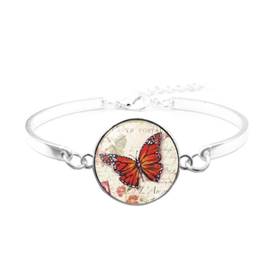 Dettaglio del bracciale farfalla vintage con motivo cartolina retrò e cupola di vetro