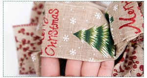 Detail of burlap Merry Christmas ribbon with green trees and red berries for tree decor
