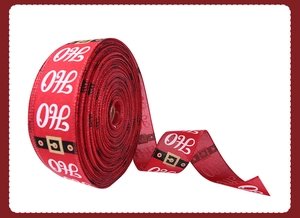 Macro detail of red Christmas ribbon with HO HO HO print and Santa belt buckle pattern