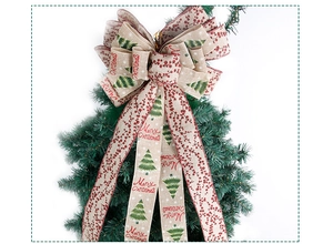 Detail of burlap Christmas tree topper bow with Merry Christmas script and pine patterns