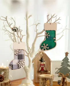 Detail of wooden Christmas stocking ornaments with plaid fabric and snowflake on white branches