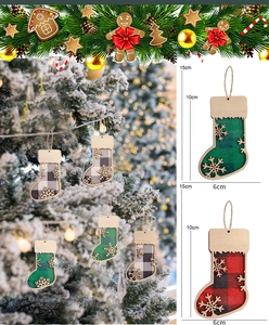 Detail of wooden Christmas sock pendant with red plaid and snowflake cutout on tree