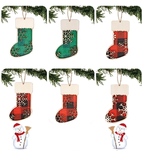 Makroansicht von Weihnachtssocken-Anhängern aus Holz mit Karomuster und Schneeflocken