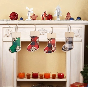 Detail of wooden Christmas sock ornaments with plaid fabric and delicate snowflake cutouts