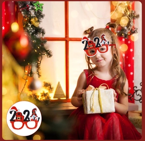 Close-up of child wearing 2024 Christmas glasses with reindeer antlers and santa hat