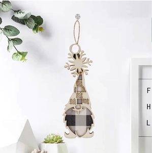 Close-up of wooden Christmas gnome ornament with plaid pattern hanging on white wall
