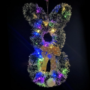 Detail eines Osterkranzes in Hasenform mit bunten LED-Lichtern und gepunkteter Schleife
