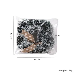 Detail of tinsel garland in package with 34x32x9cm dimensions and white bow