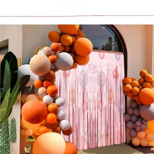 Cortina de flecos rosa con arco de globos naranjas y rosas para decoración de fiesta