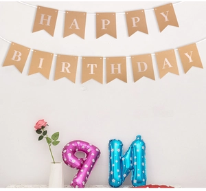 Dettaglio dello striscione Happy Birthday in carta kraft con corda bianca su muro