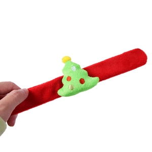 Vue détaillée du bracelet de Noël en peluche rouge avec un sapin vert décoré dessus