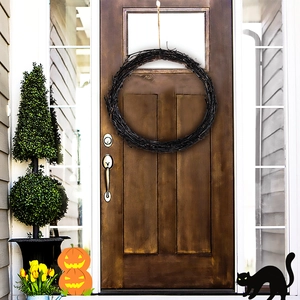 Macro shot of a black twig wreath on a wooden door for Halloween gothic home decor
