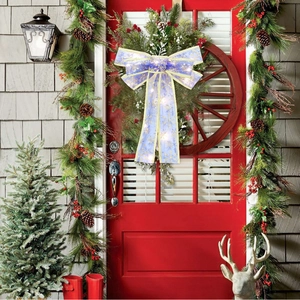 Detail of purple LED Christmas bow with gold snowflakes on a festive door wreath