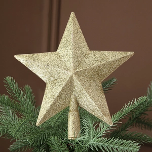 Detailed view of the sparkling gold glitter Christmas tree star topper on a pine tree