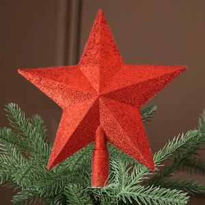 Close-up of a glittering red star tree topper with sequins for Christmas tree decoration