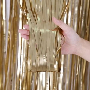 Detail of matte gold fringe curtain showing dense metallic strands and soft texture