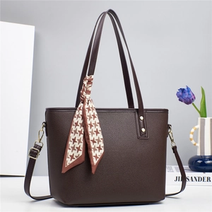 Detail of dark brown lychee textured leather bucket bag with houndstooth silk scarf handle