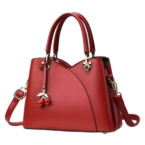 Sac à main rouge en cuir grainé avec pendentifs cerises et détails dorés chic