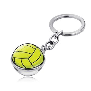 Detail of silver volleyball keychain with double-sided glass dome and vibrant yellow pattern