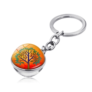 Detail view of Tree of Life glass ball pendant keychain with vibrant orange gradient background