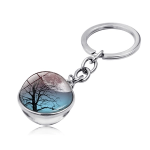 Detail of silver tree of life keychain with double-sided glass orb and moonlight scene