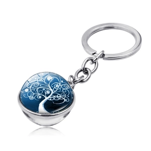 Macro shot of silver tree of life keychain with blue double-sided glass ball pendant