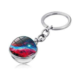 Close-up of galaxy-themed double-sided glass orb keychain with polished silver metal finish