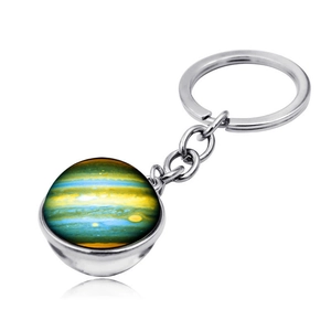 Macro detail of Jupiter glass ball pendant with silver metal keychain on white background