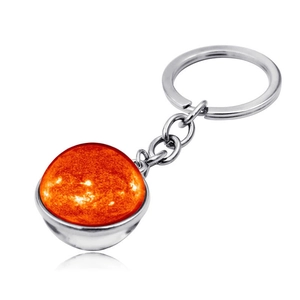 Macro shot of solar flare galaxy pattern in a double-sided glass orb keychain pendant