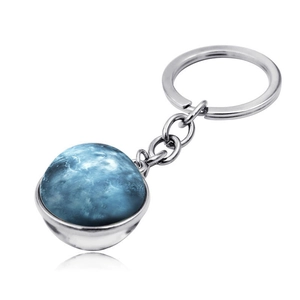 Detail shot of a double-sided blue galaxy glass ball keychain with silver metal ring