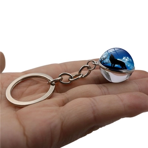 Double-sided glass ball keychain featuring a howling wolf silhouette against a starry night sky