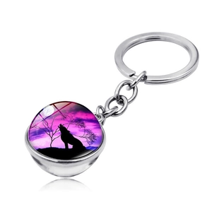 Detail view of double-sided glass dome keychain with purple howling wolf silhouette