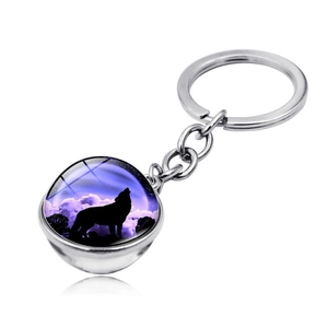 Detailed view of the glass dome keychain with a howling wolf silhouette in a starry sky