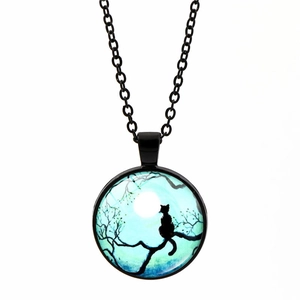 Vue détaillée du pendentif rond en alliage avec illustration de chat noir et lune bleue