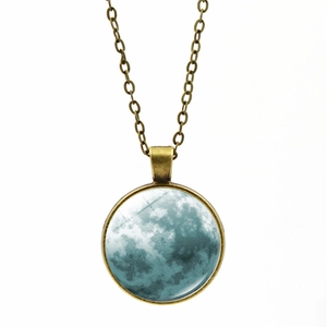 Gros plan du pendentif en bronze avec texture de lune bleue en pierre de verre