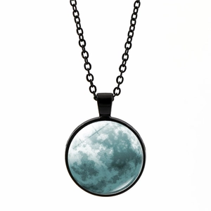 Détail macro du pendentif rond en verre avec texture de lune bleue et cadre noir