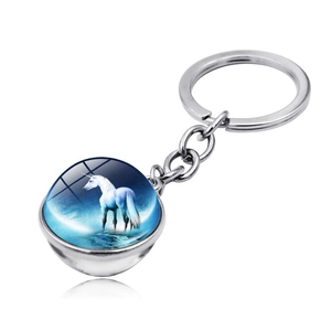 Detailed macro view of double-sided unicorn glass ball pendant on silver keychain