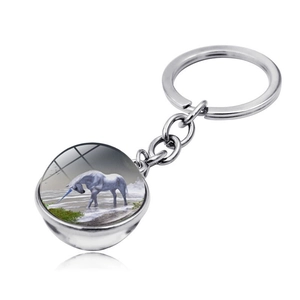 Macro view of a unicorn illustration under a glass cabochon silver keychain