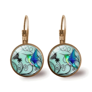 Boucles d'oreilles colibri vintage en bronze avec cabochon en verre bleu sur fond blanc